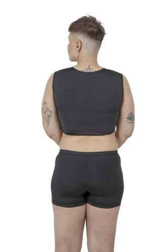 Back view of model wearing black Packer Swim Trunks and coordinating compression binder.