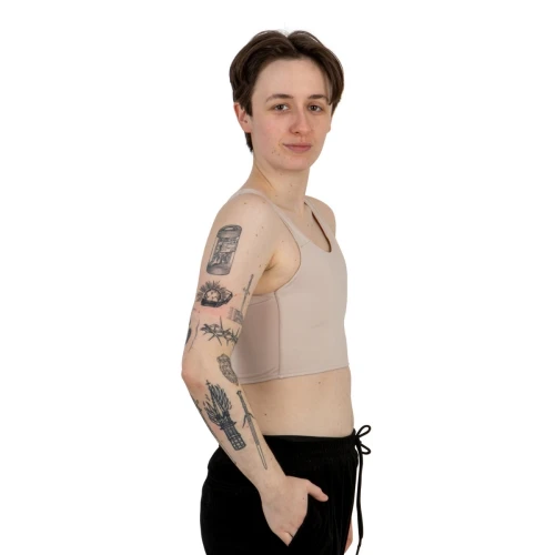 Beżowy kompresyjny binder wąskie ramiączka, widziany z boku. Odzież gender-affirming zapewniająca płaski profil.